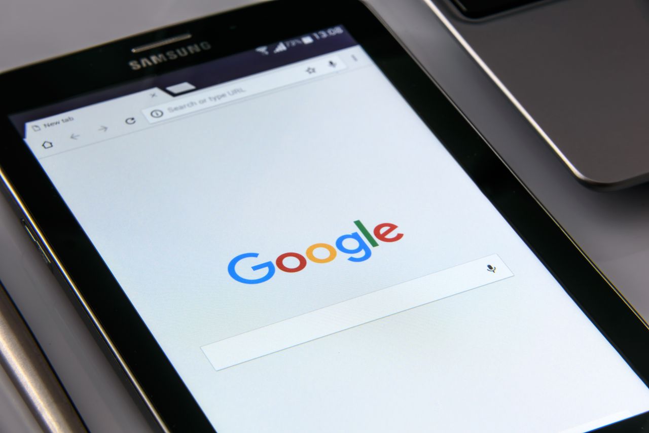 mobile-02 Close-up of a tablet displaying Googles search screen, emphasizing technology and internet browsing.