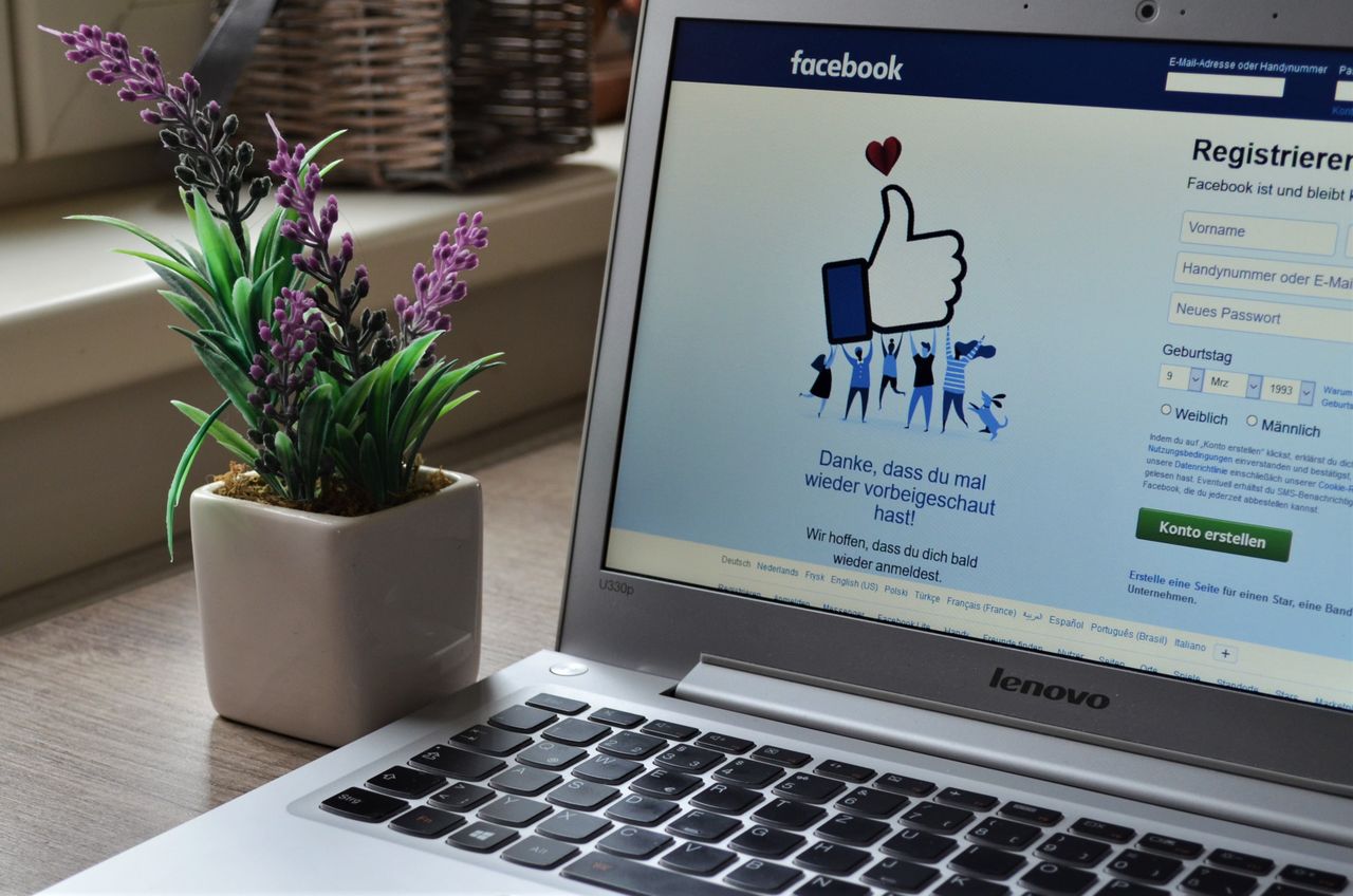 Services-01 A Lenovo laptop displaying Facebook login beside a lavender plant indoors.